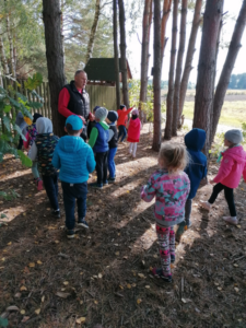 Grupa dzieci idzie po lesie.