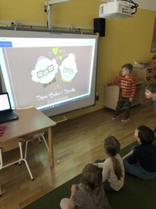 Dzieci przyglądają się tablicy multimedialnej